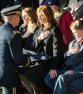 Army Major General presents a flag to a widow and her children