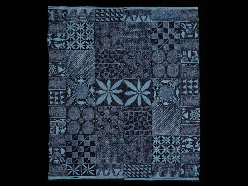 Image of a quilt made in shades of blue and black. 