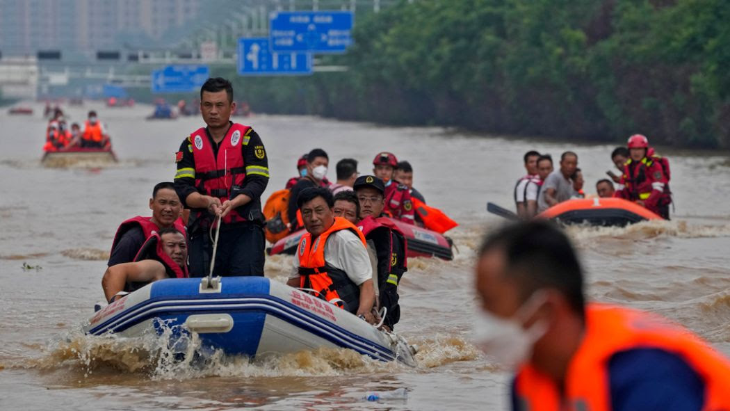 Evacuees fill rubber boats in flooded streets in China.