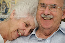 A smiling older couple sitting together.