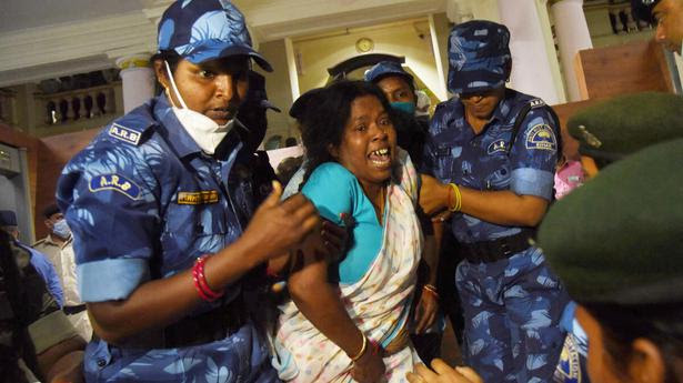 Security personnel remove a Grand Alliance legislator during the budget session of the Bihar Assembly in Patna on March 23, 2021.