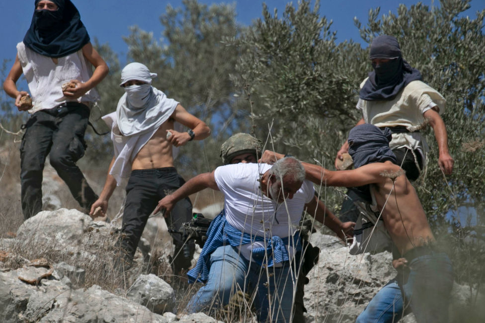 Masked Israeli settlers attack Palestinian olive farmers in the West Bank in October 2020