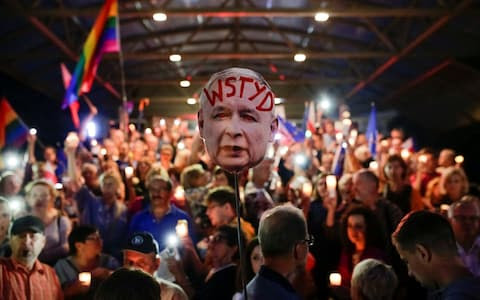 Protestors in Krakow hold a sign that reads "Shame", depicting Law and Justice party leader Jaroslaw Kaczynski