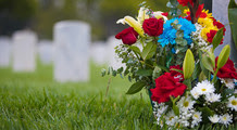 flowers next to headstone at cemetery