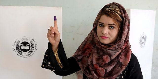 An Afghan woman shows her inked finger after casting her vote at a polling station in Kabul, Afghanistan, Saturday, Sept. 28, 2019. Afghans headed to the polls on Saturday to elect a new president amid high security and threats of violence from Taliban militants, who warned citizens to stay away from polling stations or risk being hurt. (AP Photo/Ebrahim Noroozi)