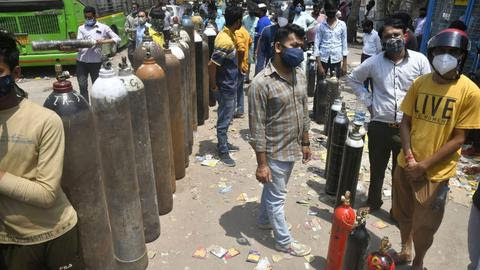 Relatives of COVID-19 patients wait to refill cylinders with medical oxygen at Naraina plant during the second wave of coronavirus pandemic, in New Delhi on April 27, 2021.