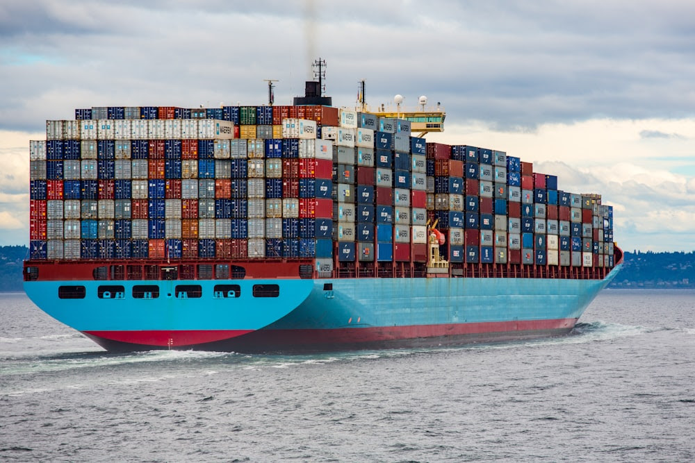 cargo bleu et rouge en mer pendant la journée