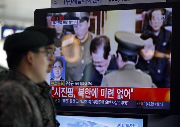 Soldados surcoreanos pasan junto a un televisor que muestra informes sobre la ejecución de Jang Song Thaek, quien es tío del líder norcoreano Kim Jong Un, en una estación de ferrocarril en Seoul 13 diciembre de 2013.  REUTERS / Kim Hong-Ji