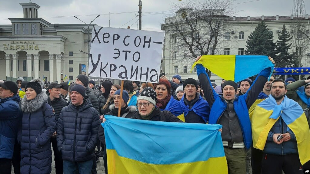 Người biểu tình giương cờ Ukraine và biểu ngữ 'Kherson là của Ukraine' tại một cuộc biểu tình chống quân chiếm đóng Nga ở Quảng trường Tự do ở Kherson