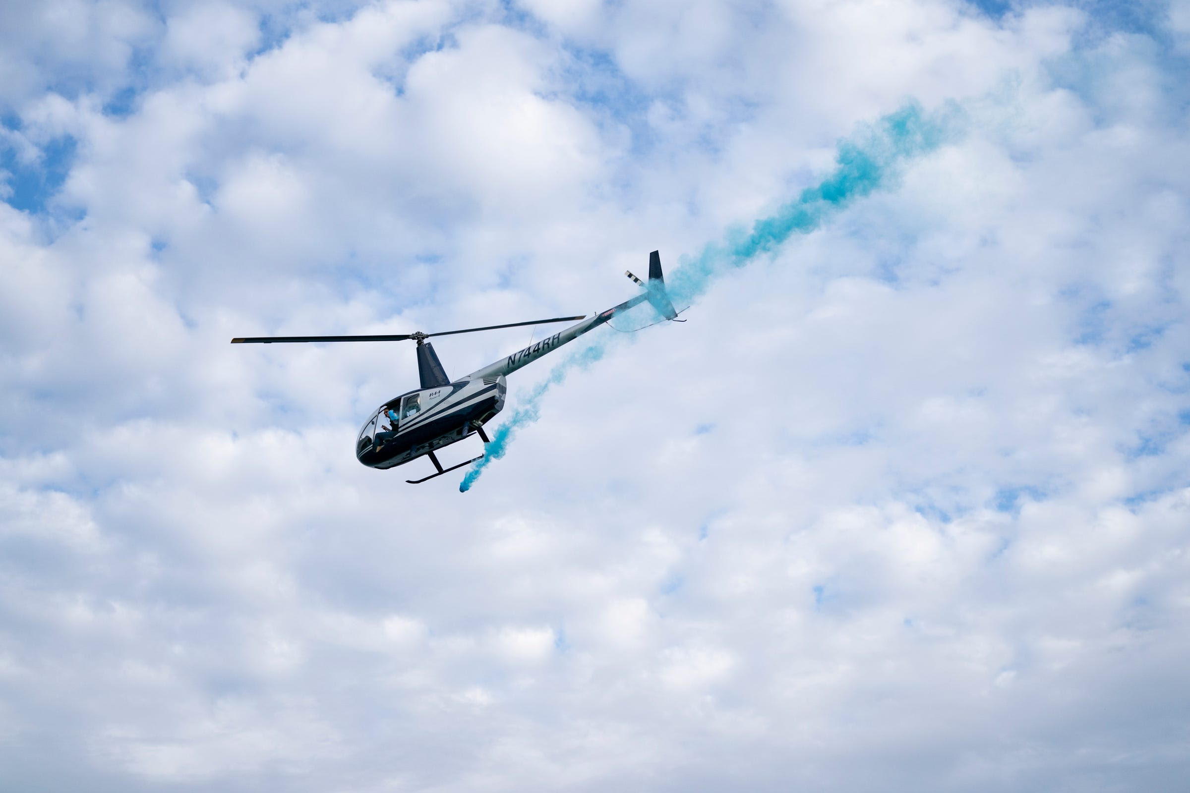 Max Flight Helicopter Services releases a blue powder over the Detroit River as part of a gender reveal party organized by Drew Roberts and Chi Chi Dean for their first child.  The two, along with some friends, took a chartered power boat through Riverwise Detroit Boat Tours out of the Grayhaven State Harbor for the gender reveal.