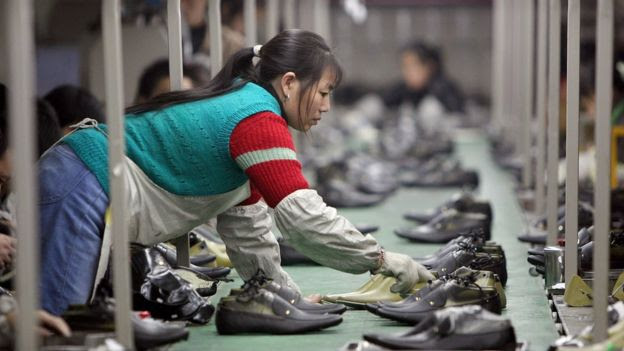 Mulher trabalha em loja de sapatos na China