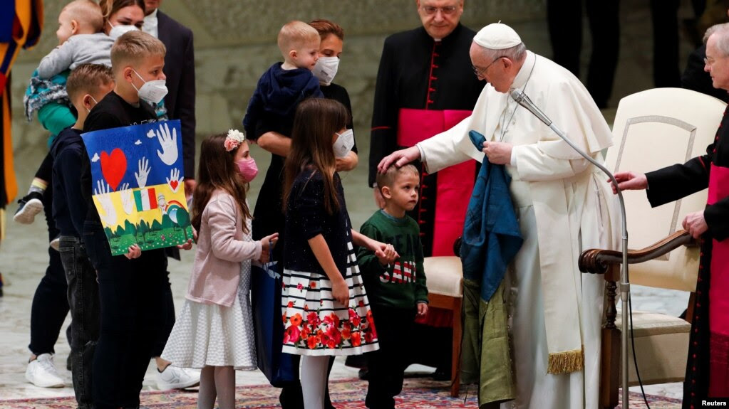 Giáo hoàng Phanxicô cầm lá cờ Ukraine sẫm màu được gửi đến từ Bucha trong lúc ông gặp các trẻ em Ukraine trong buổi tiếp kiến ở Vatican vào ngày 6/4/2022.