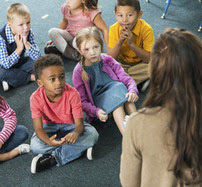 Teacher talking to small children.