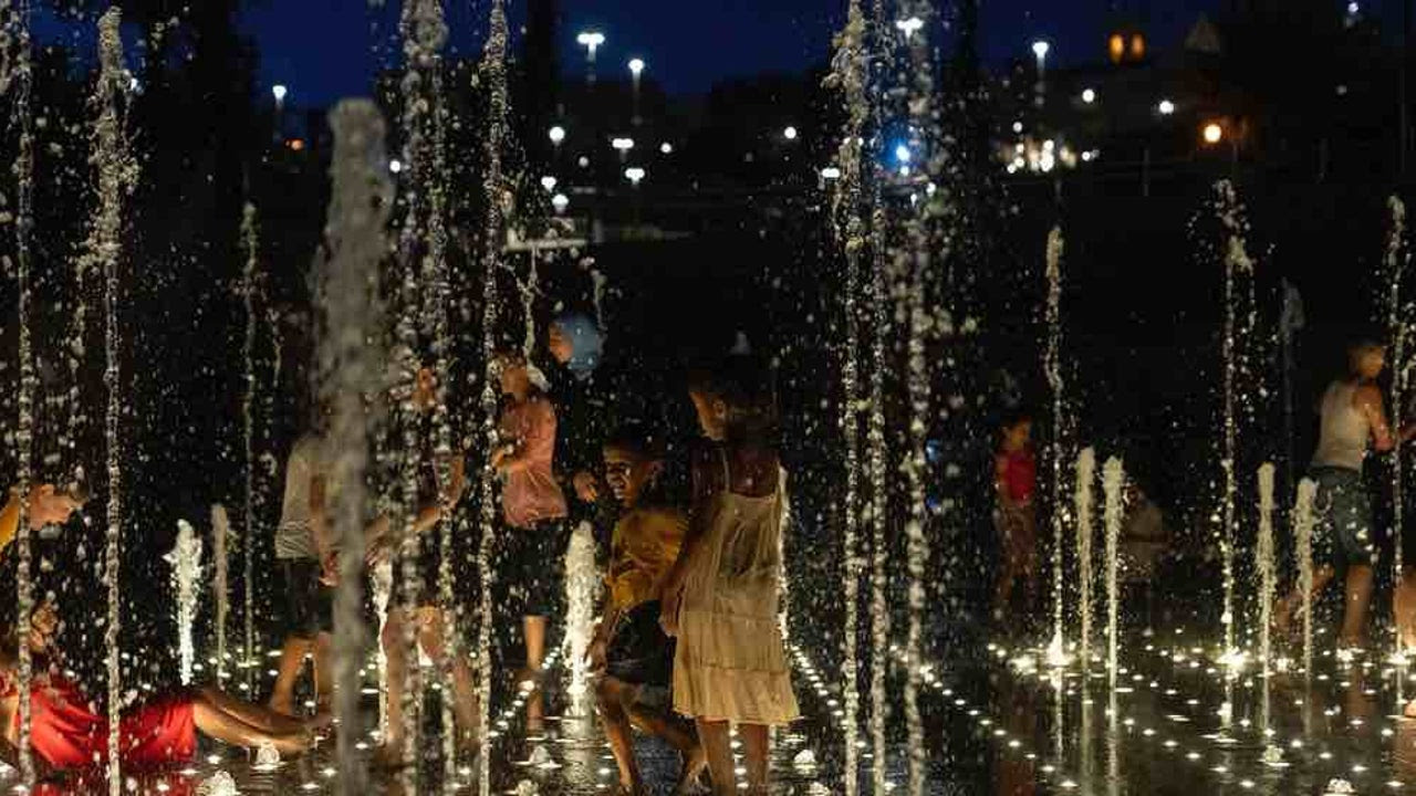 children cooling off in a fountain.