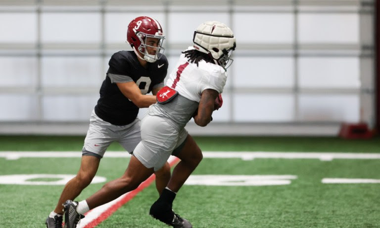 Alabama quarterback Bryce Young (#9) hands the ball to running back Jahmyr Gibbs (#1) in bowl practice for Kansas State.