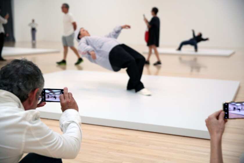 Visitors photograph the live sculptures in artist Xu Zhen’s “In Just a Blink of an Eye.” MOCA acquired the performance piece for its permanent collection. 