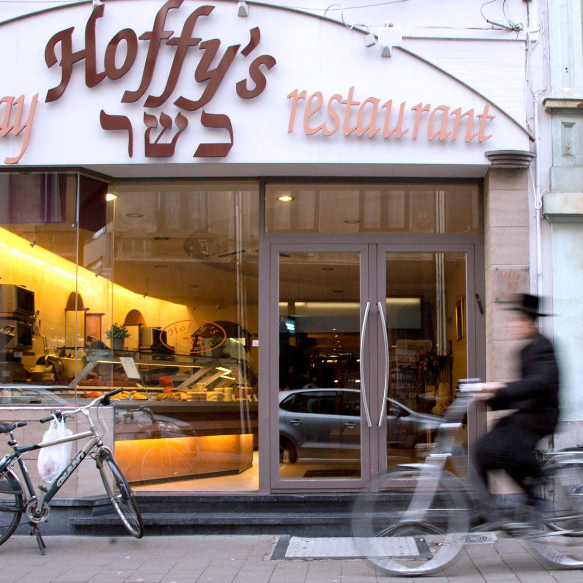 A Jewish boy rides his bike past a take-away restaurant in Antwerp, Belgium, January 16, 2015.