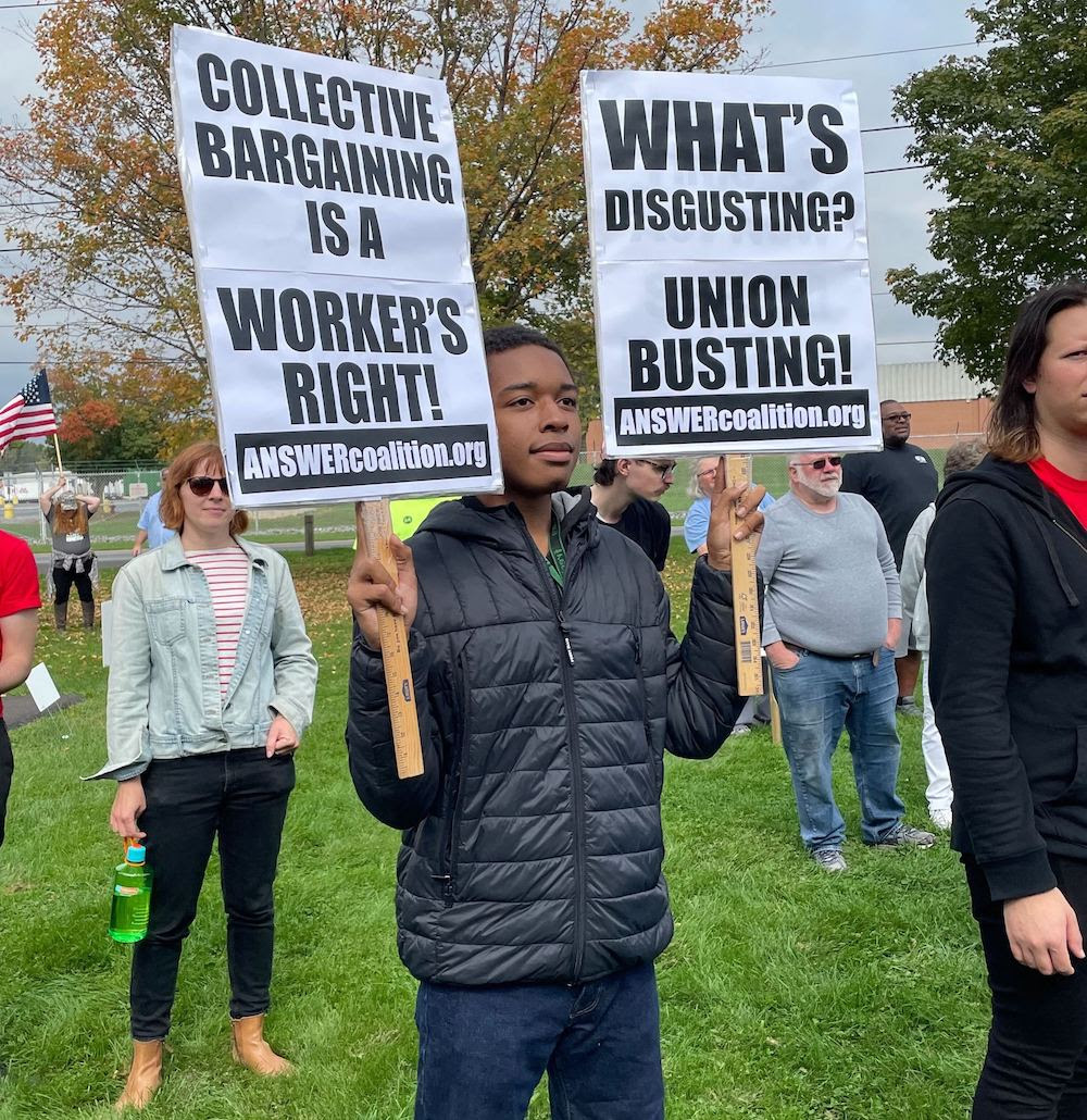 A young person holds up union signs at the strike.