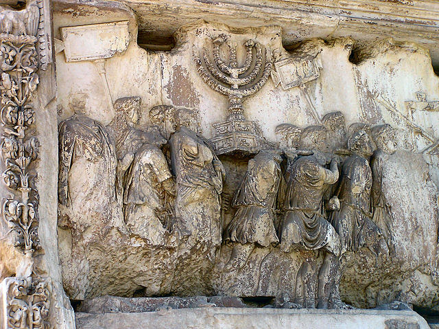 The Arch of Titus in Rome, Italy - In this part of Titus' triumphal procession, the treasures of the Jewish Holy Temple in Jerusalem are being displayed to the Roman people. Hence the seven-branched Menorah.
