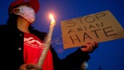 Stati Uniti: Una donna con una candela e un cartello contro la discriminazione razziale