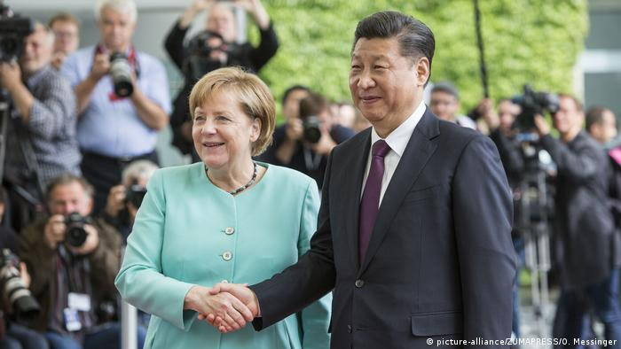 Merkel aperta a mão do presidente chinês, Xi Jinping