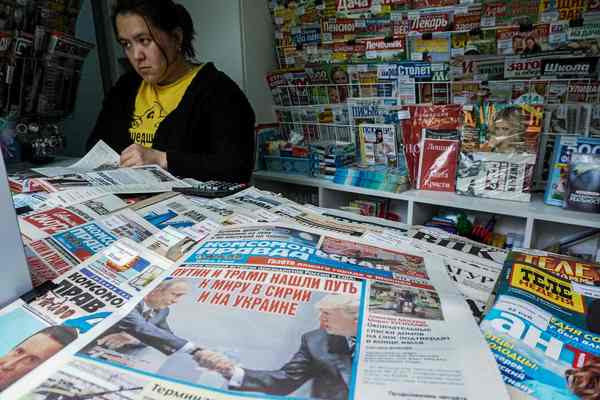 A woman browses in a Moscow newsstand among papers featuring President Trump and Russian President Vladimir Putin on July 8. (Kirill Kudryatsev/Agence France-Presse via Getty Images)</p>