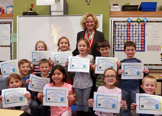 First-grade students hold up their Certificates of Completion for the Hour of Code with State Superintendent Jillian Balow.