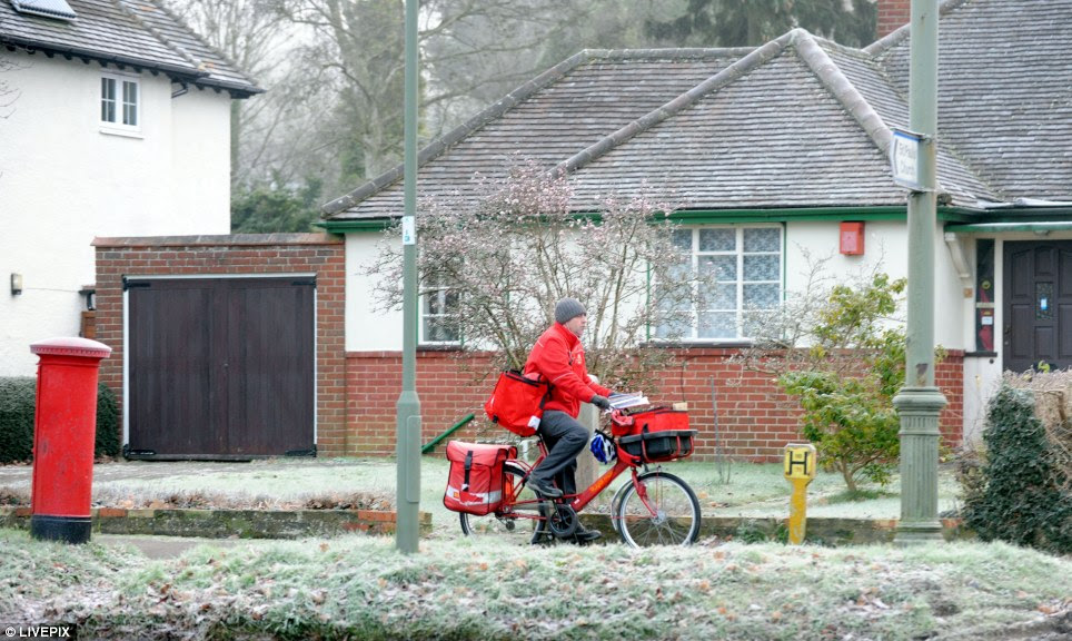 Dedicated delivery: A Royal Mail postman braved temperatures of minus three in Banstead Village, Surrey, this morning