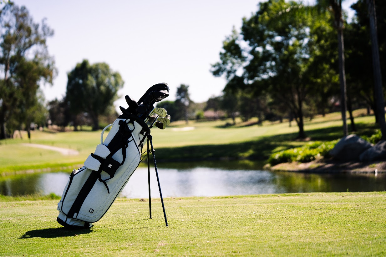 A golf bag on a golf course

Description automatically generated