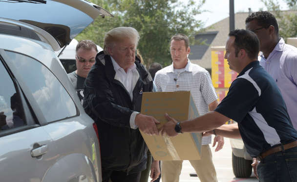 Slide 4 of 12: President Donald Trump helps load donated items for people impacted by Hurricane Harvey during a visit to First Church of Pearland in Pearland, Texas, Saturday, Sept. 2, 2017. (AP Photo/Susan Walsh)
