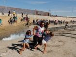 Una familia de migrantes huye de los gases lacrimógenos lanzados desde la frontera entre Estados Unidos y México en Tijuana. Foto: Kim Kyung-Hoon/ Reuters. caravana-migrante-en-frontera-kim-kyung-hoon-reuters