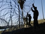 Members of the U.S. military install multiple tiers of concertina wire along the banks of the Rio Grande near the Juarez-Lincoln Bridge at the U.S.-Mexico border in Laredo, Texas. (AP Photo/Eric Gay, File)