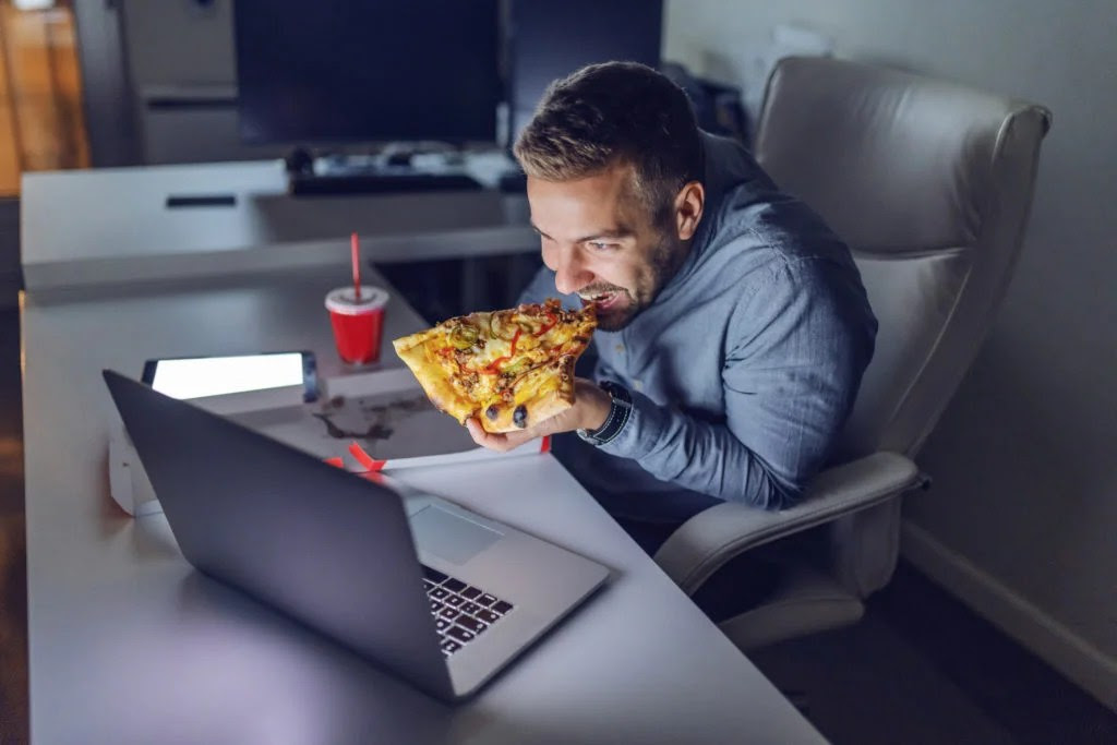 Man eating pizza at night