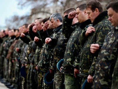 Soldados ucranianos de la base de Belbek, cerca de Simferópol, se santiguan tras rezar por la paz en una ceremonia religiosa. REUTERS/Thomas Peter