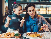 mom and daughter eating at restaurant