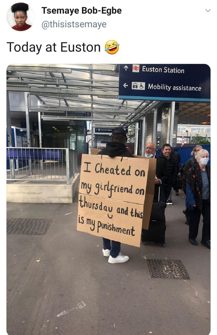 Man seen in the streets of London wearing cardboard that reads: "I cheated on my girlfriend and this is my punishment"