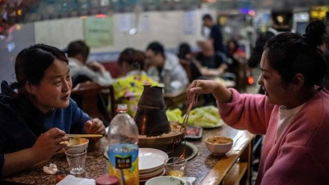 Chinas comiendo en un restaurant en Pekín.