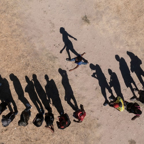 Haitian migrants standing in a line.