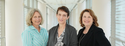 Karen Baker, Dr. Colleen Hadigan and Victoria Anderson stand in a hallway