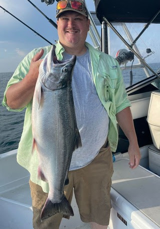 An angler holding a coho salmon