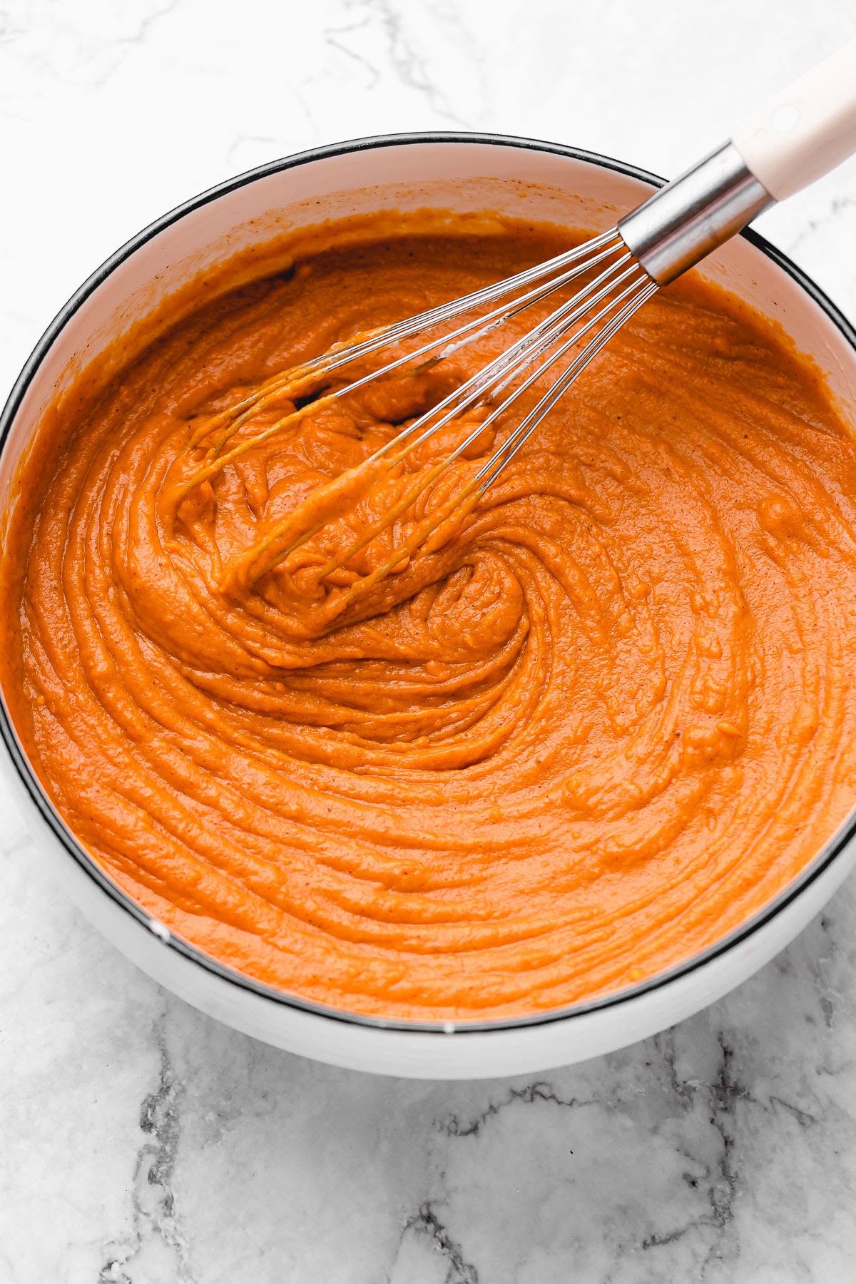 This Vegan Sweet Potato Pie is just like the Southern classic, but made without the dairy and eggs. Sweet, creamy, and perfect! Sweet potato pie filling in bowl with whisk