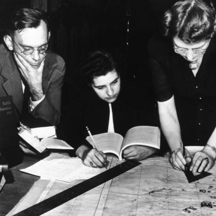 Photograph of Bill Burke, Jane Mull, and Gladys Hamlin preparing a map at the Frick Art Reference Library