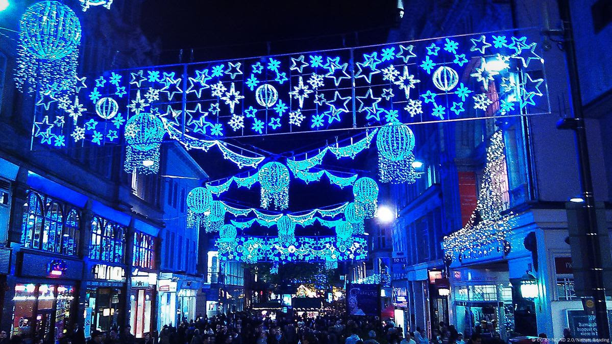 Rua com luzes natalinas à noite.