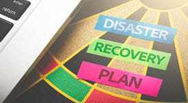 Dart board with post it stickies that say "Disaster Recovery Plan"