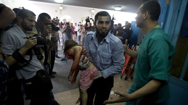 A medic carries a young girl killed on Sunday in Al-Shuja'iya