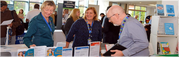 image of 3 people visiting an informational booth at BizFair