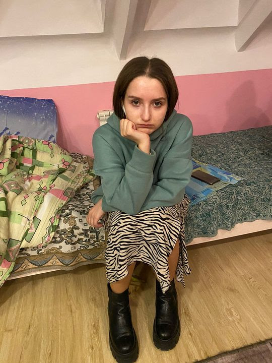 A lone girl sitting on a couch in the Pinsk Girls Dormitory