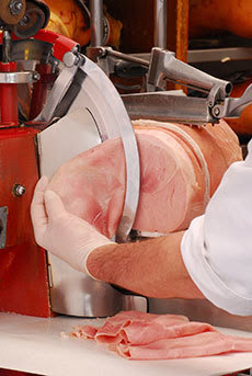 Deli Slicer slicing meat.