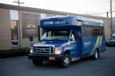 Blue bus outside of a building