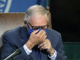 Washington Gov. Jay Inslee puts on a face mask as he concludes a news conference, Tuesday, June 23, 2020, at the Capitol in Olympia, Wash. Inslee announced Tuesday that Washington state will require people to wear facial coverings in most indoor and outdoor public settings, under a statewide public health order in response to ongoing COVID-19 related health concerns. (AP Photo/Ted S. Warren)